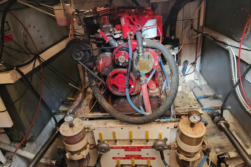 Part Of The Plan Yacht Photos Pics Engine room of a 1990 Grand Banks 46 Classic yacht, featuring a red engine.