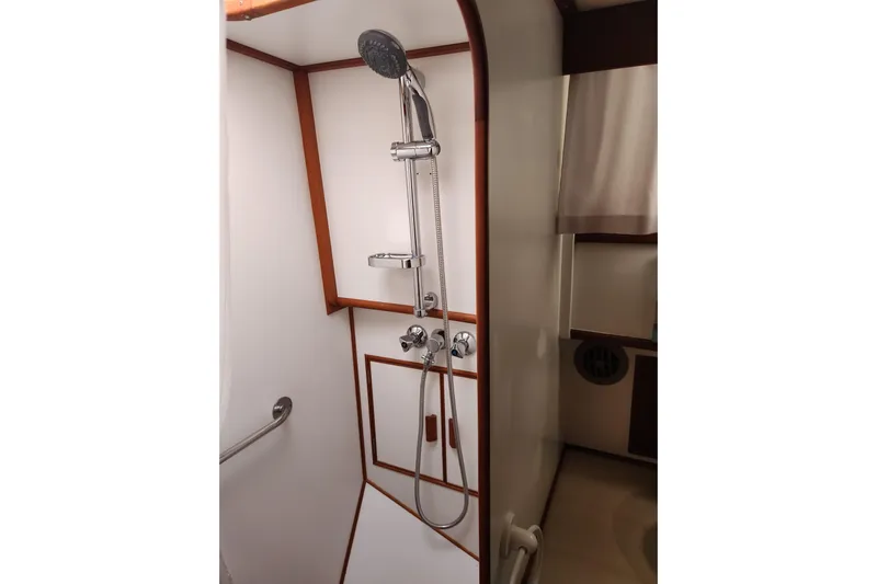 Part Of The Plan Yacht Photos Pics Shower area in 1990 Grand Banks 46 Classic yacht, featuring modern fixtures and wooden accents.