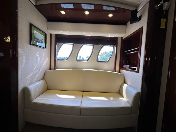 Mia Yacht Photos Pics Luxurious interior of 2009 Sea Ray 60 Sundancer yacht with cream sofa and porthole windows.