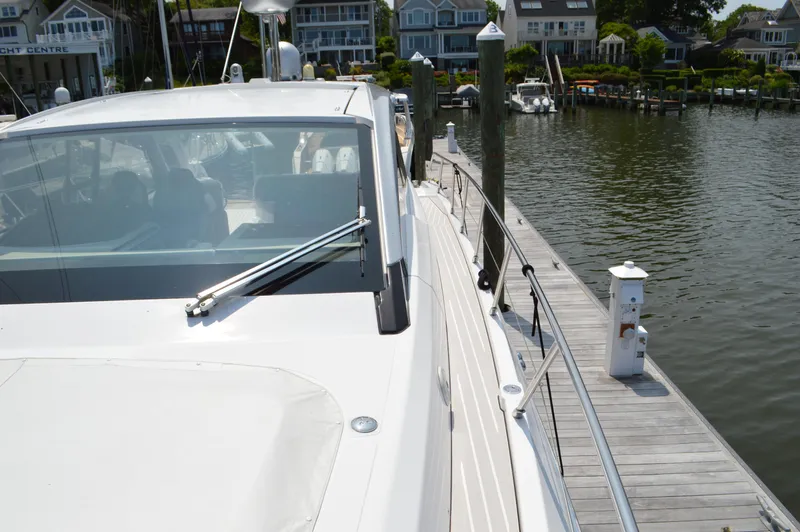 Amici Yacht Photos Pics 2019 Azimut Atlantis 51 yacht docked at a marina, showcasing sleek design and waterfront homes.