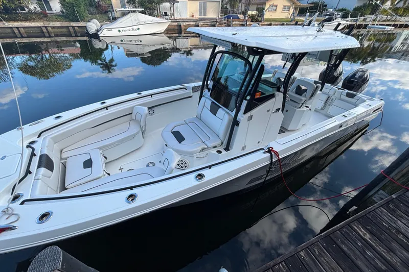  Yacht Photos Pics 2021 Wellcraft 302 Fisherman boat docked on calm water, showcasing sleek design and spacious seating.
