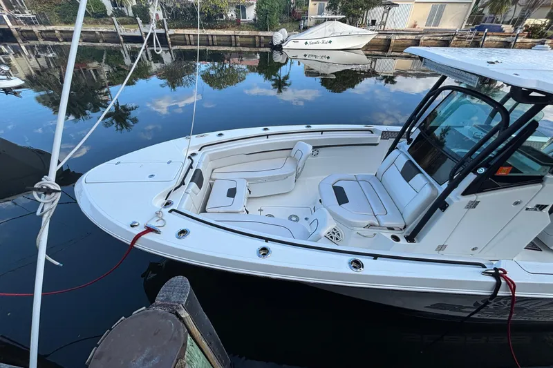  Yacht Photos Pics 2021 Wellcraft 302 Fisherman boat docked on calm water, showcasing sleek design and seating.