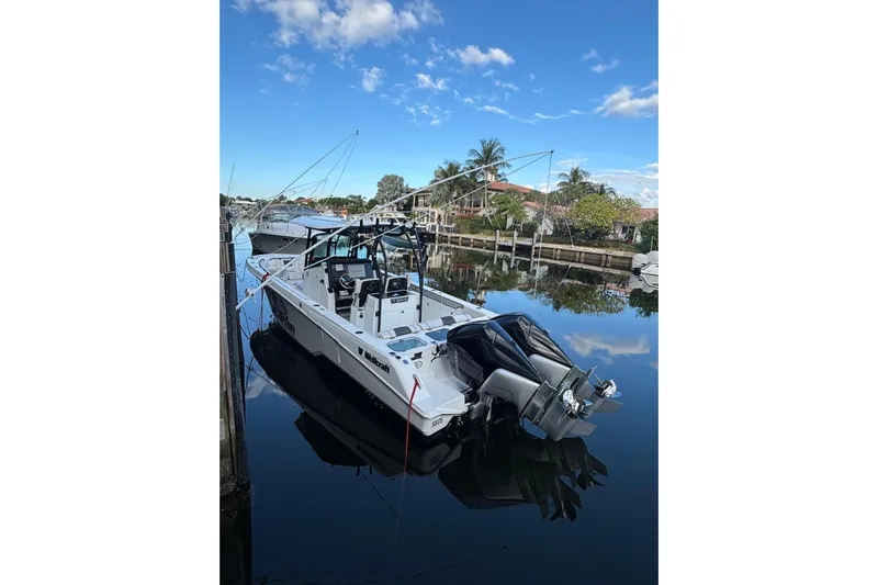  Yacht Photos Pics 2021 Wellcraft 302 Fisherman boat docked on a calm, sunny day.