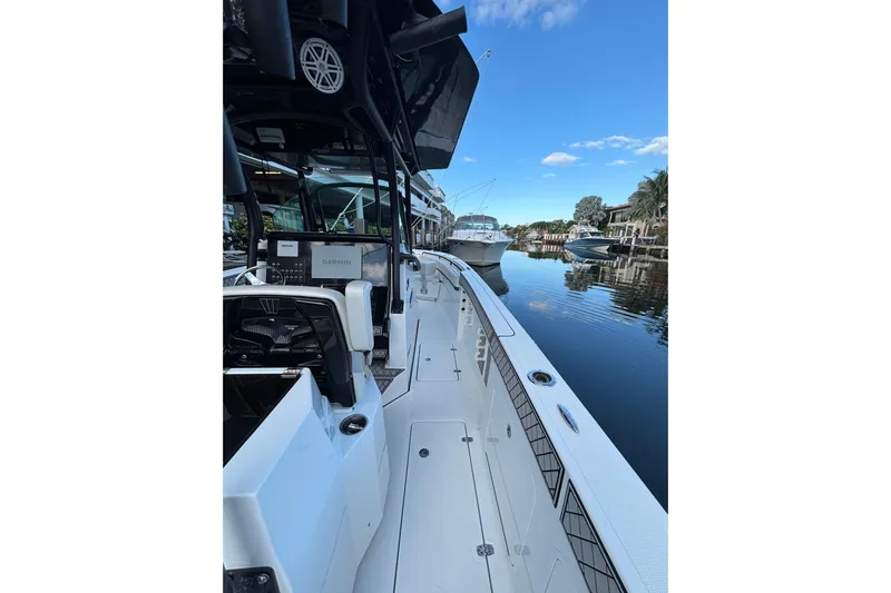  Yacht Photos Pics 2021 Wellcraft 302 Fisherman boat docked on a calm waterway under a clear blue sky.