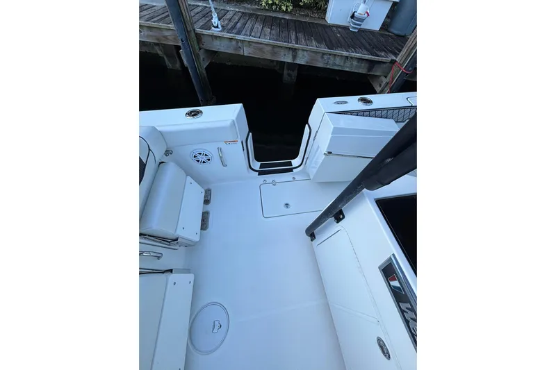  Yacht Photos Pics 2021 Wellcraft 302 Fisherman boat interior, featuring seating and storage near a dock.