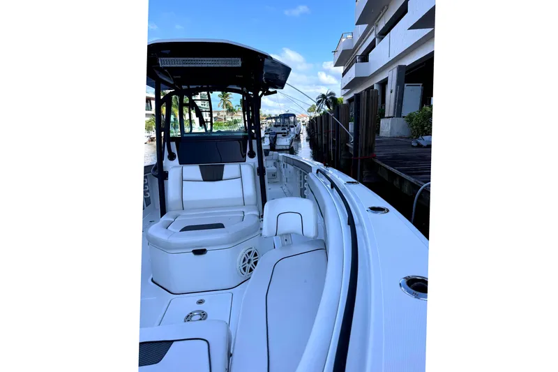  Yacht Photos Pics 2021 Wellcraft 302 Scarab boat docked, featuring sleek white seating and modern design.