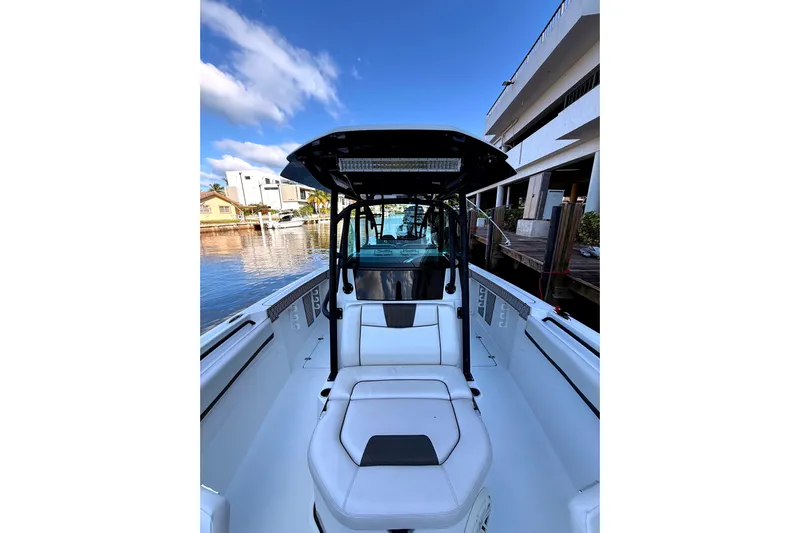  Yacht Photos Pics 2021 Wellcraft 302 Scarab boat interior with seating, docked by waterfront buildings.