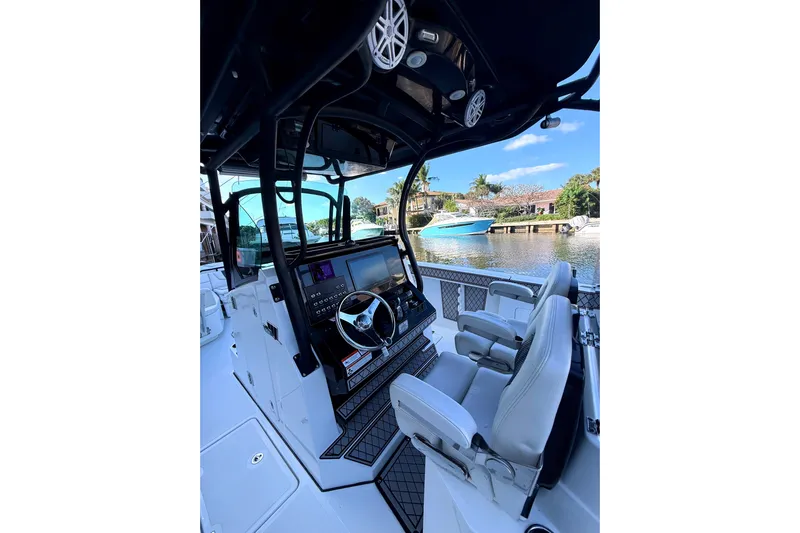  Yacht Photos Pics 2021 Wellcraft 302 Scarab boat interior with modern helm and seating, docked by waterfront.