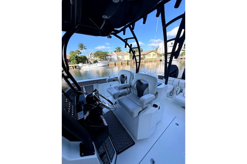  Yacht Photos Pics 2021 Wellcraft 302 Scarab boat interior with dual seats and steering wheel, dockside view.