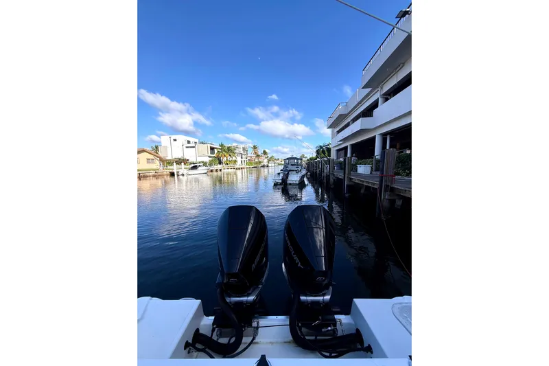  Yacht Photos Pics 2021 Wellcraft 302 Scarab boat with dual engines on a sunny waterfront.