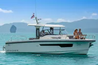 Nimbus T11 2022 boat cruising on turquoise waters with scenic mountain backdrop.