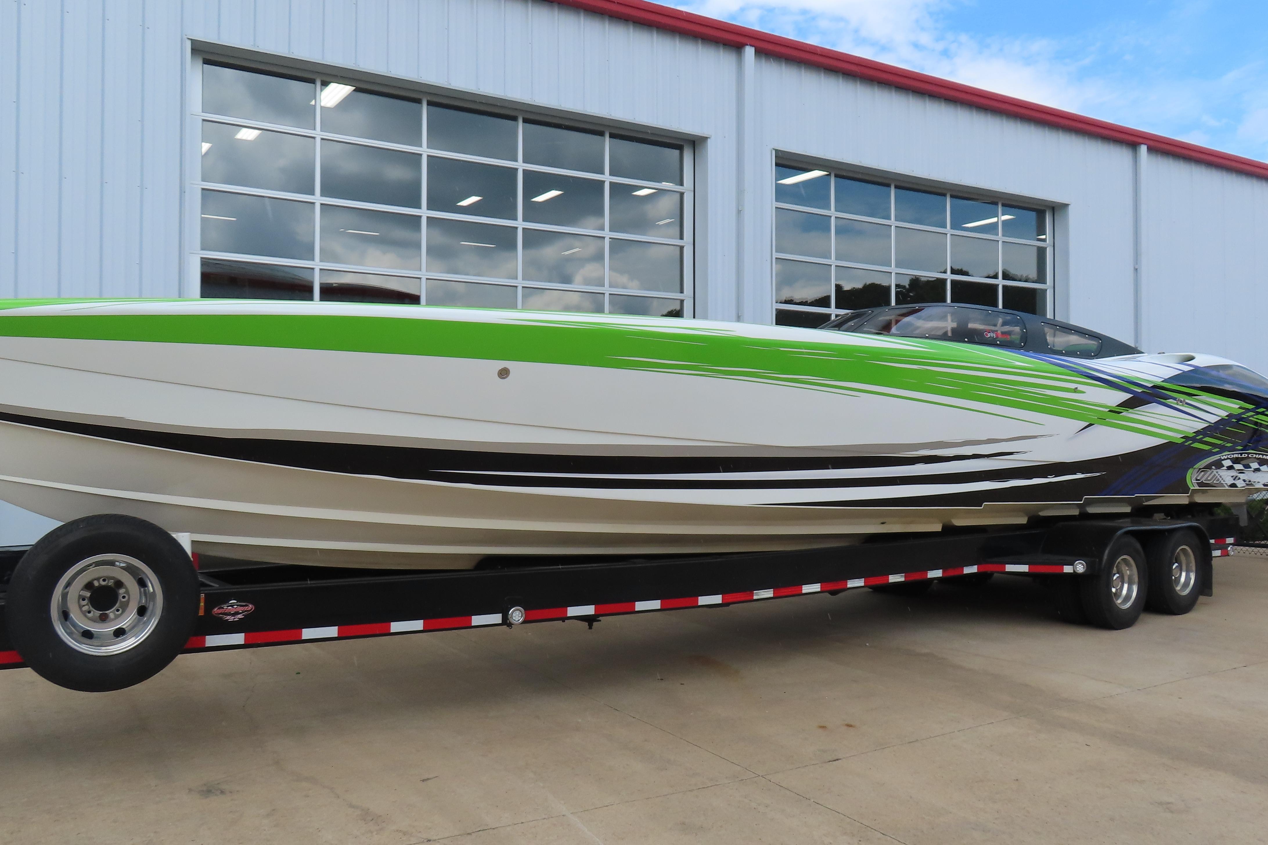 2007 Outerlimits 44 GTX speedboat on trailer, vibrant green and white design.