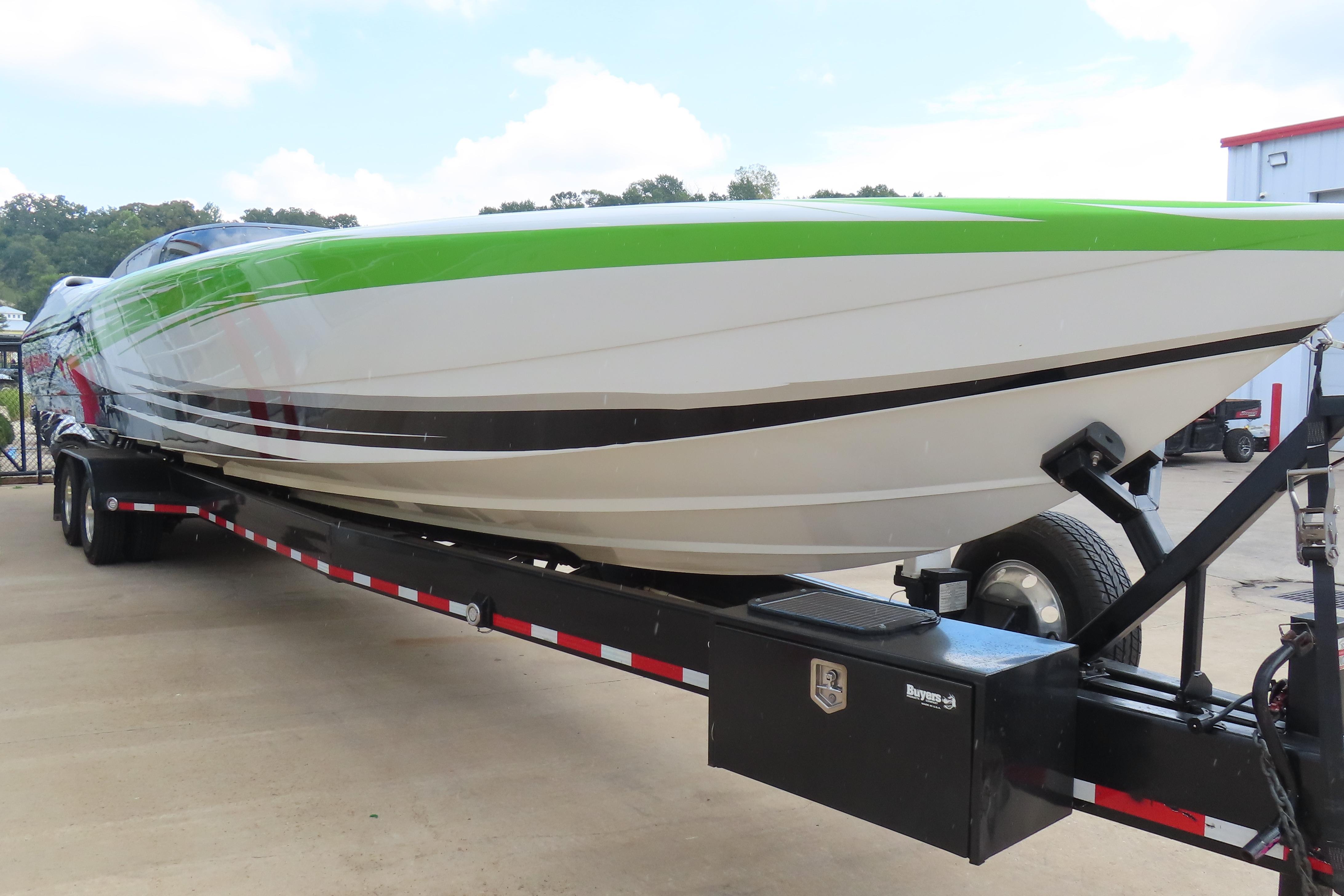 2007 Outerlimits 44 GTX powerboat on trailer, featuring a sleek green and white design.