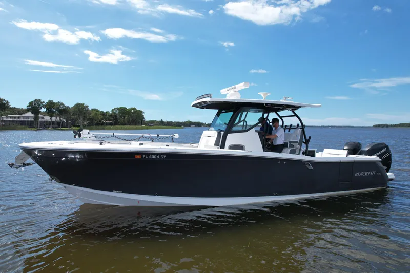  Yacht Photos Pics 2021 Blackfin 332 CC boat on calm water under a clear blue sky.