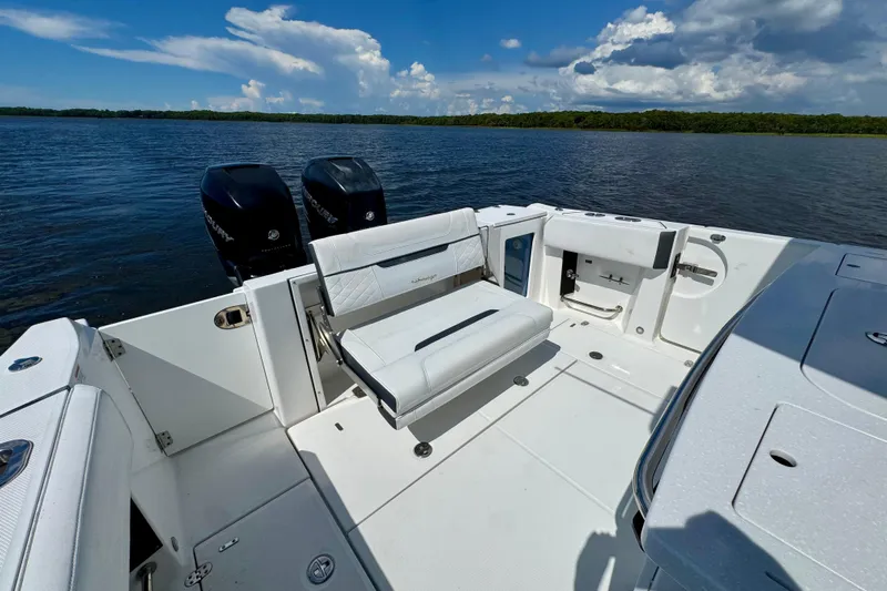  Yacht Photos Pics 2021 Blackfin 332 CC boat interior with seating and twin outboard engines on a sunny day.