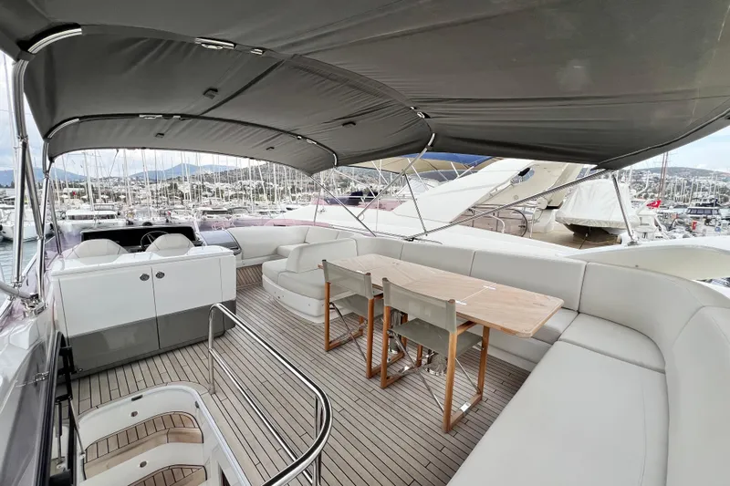  Yacht Photos Pics Luxurious 2021 Princess F55 yacht deck with seating and dining area, docked at marina.