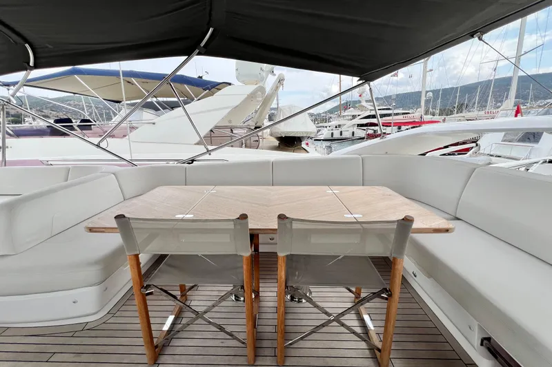  Yacht Photos Pics Luxurious 2021 Princess F55 yacht deck with seating and table, docked at marina.