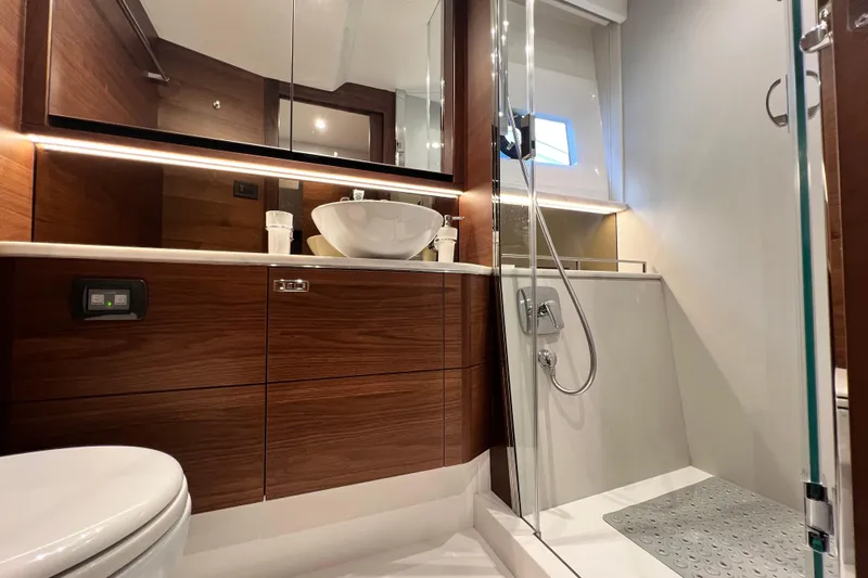  Yacht Photos Pics Luxurious bathroom in 2021 Princess F55 yacht with modern fixtures and elegant wood cabinetry.