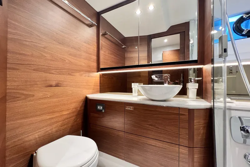  Yacht Photos Pics Luxurious 2021 Princess F55 yacht bathroom with wood paneling and modern fixtures.