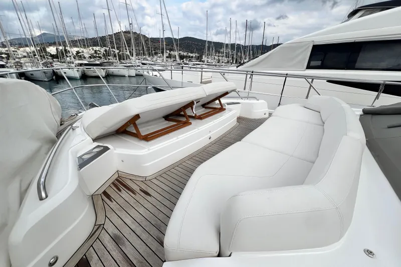  Yacht Photos Pics Luxurious 2021 Princess F55 yacht with elegant white seating and wooden deck in marina.