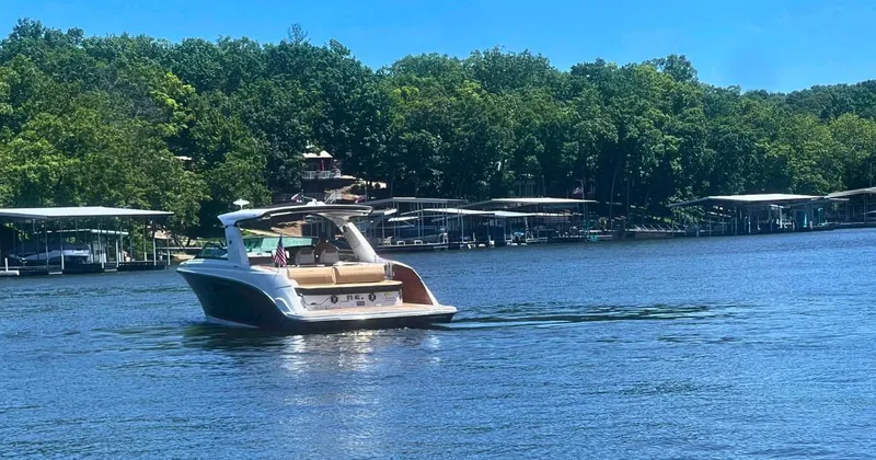  Yacht Photos Pics 2022 Sea Ray 400 SLX cruising on a serene lake with lush green shoreline.