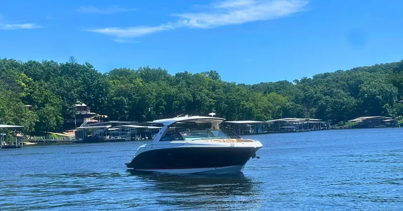  Yacht Photos Pics 2022 Sea Ray 400 SLX boat cruising on a serene lake with lush green shoreline.