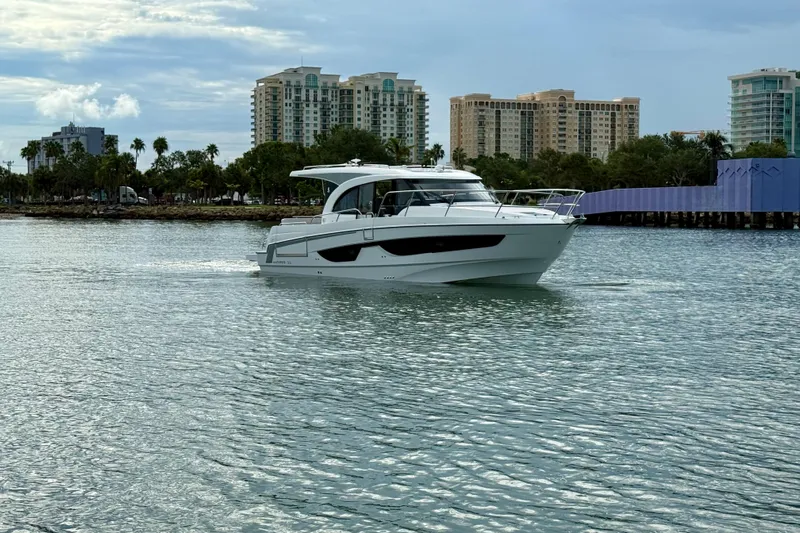  Yacht Photos Pics 2026 Beneteau Antares 11 cruising on calm waters near urban skyline.