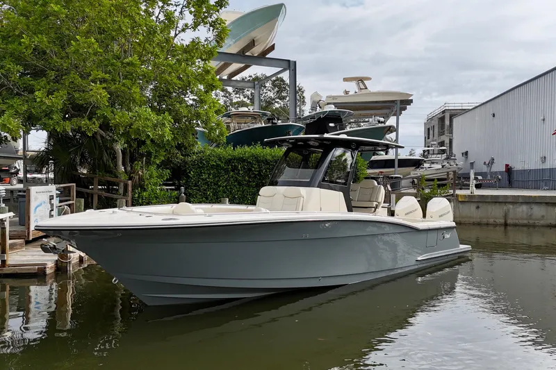  Yacht Photos Pics 2026 Scout 288 LXF boat docked near marina, surrounded by trees and buildings.