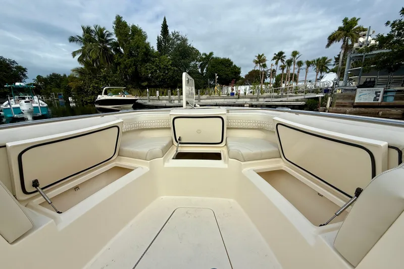  Yacht Photos Pics 2026 Scout 288 LXF boat interior with seating and storage, docked near palm trees.