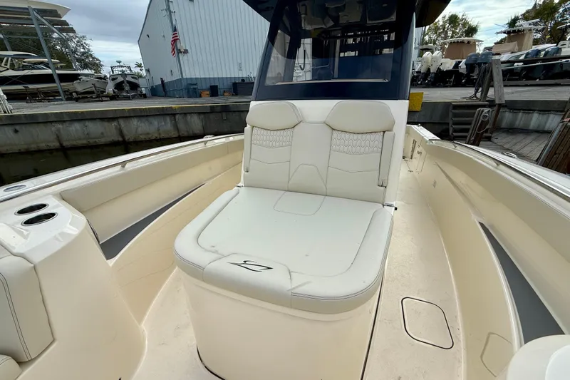 Yacht Photos Pics 2026 Scout 288 LXF boat interior with cushioned seating and cup holders at a marina.