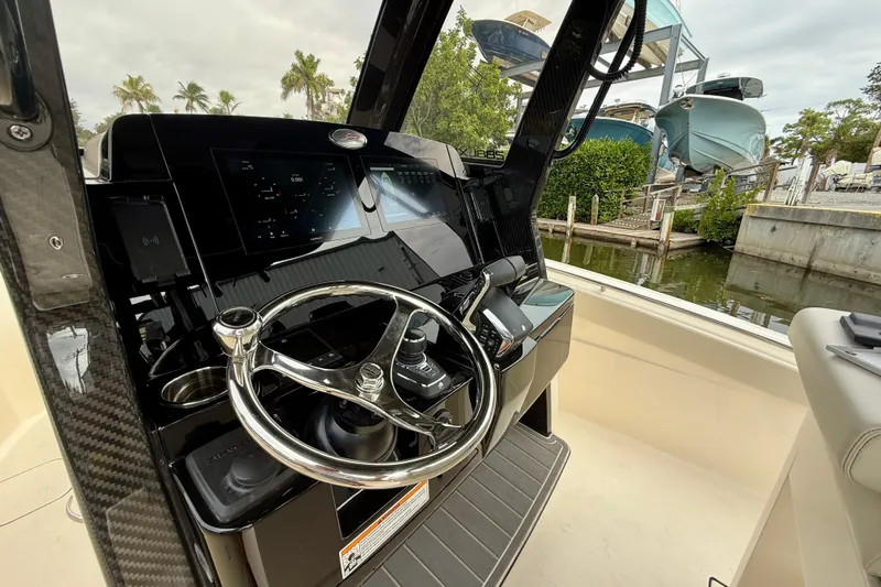  Yacht Photos Pics 2026 Scout 288 LXF boat helm with modern controls and steering wheel, dockside view.