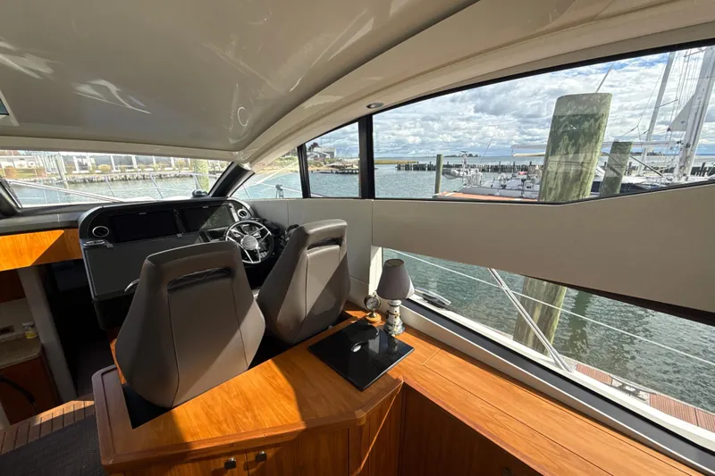Wine Tyme Yacht Photos Pics Interior view of 2016 Sunseeker Predator 57 yacht helm with marina backdrop.