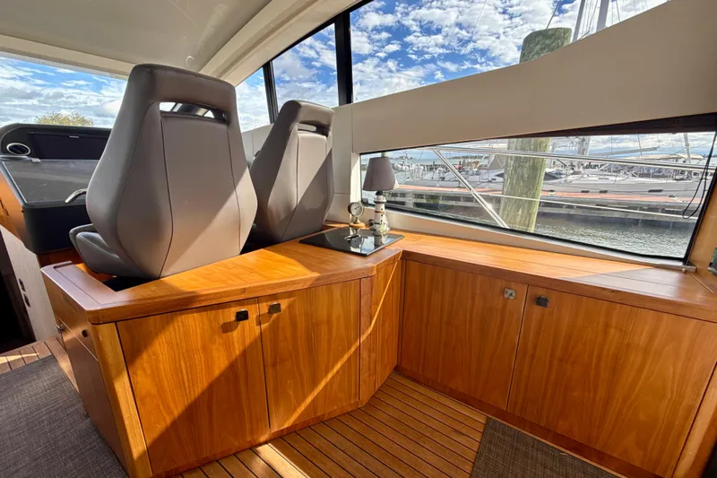 Wine Tyme Yacht Photos Pics Interior of 2016 Sunseeker Predator 57 yacht with wooden cabinetry and large windows.