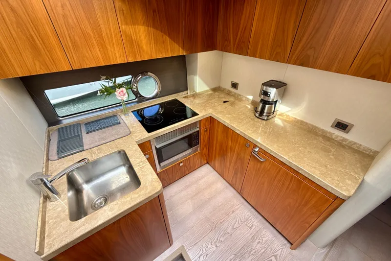 Wine Tyme Yacht Photos Pics Luxurious 2016 Sunseeker Predator 57 yacht kitchen with modern appliances and elegant wood cabinetry.