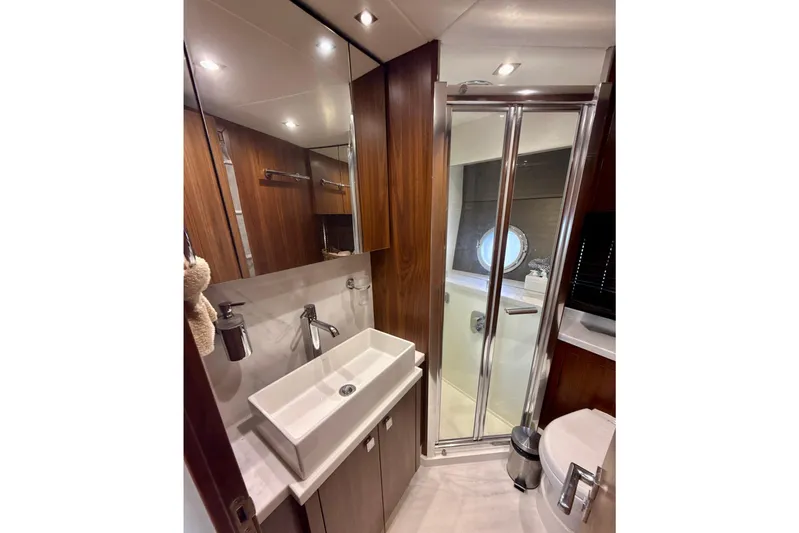 Wine Tyme Yacht Photos Pics Luxurious bathroom in 2016 Sunseeker Predator 57 yacht with modern fixtures and wood accents.