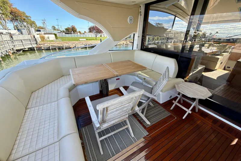 Wine Tyme Yacht Photos Pics Luxurious 2016 Sunseeker Predator 57 yacht deck with elegant seating and wooden table.