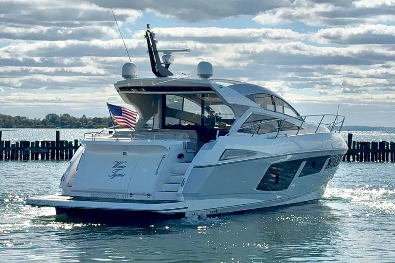 Wine Tyme Yacht Photos Pics 2016 Sunseeker Predator 57 yacht on water, American flag, sunny day.