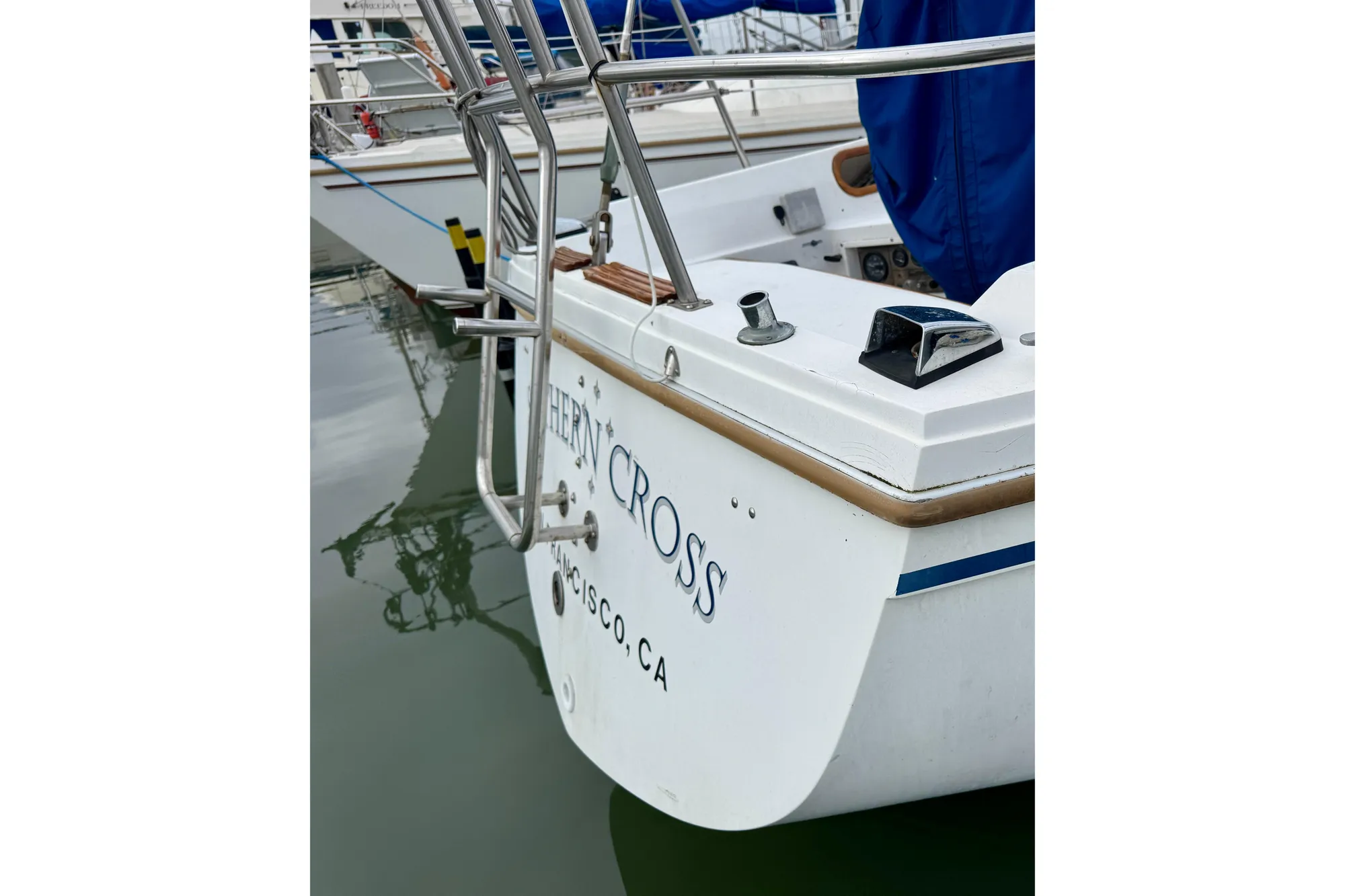 1986 Catalina 36 sailboat stern view in marina, featuring stainless steel railings.