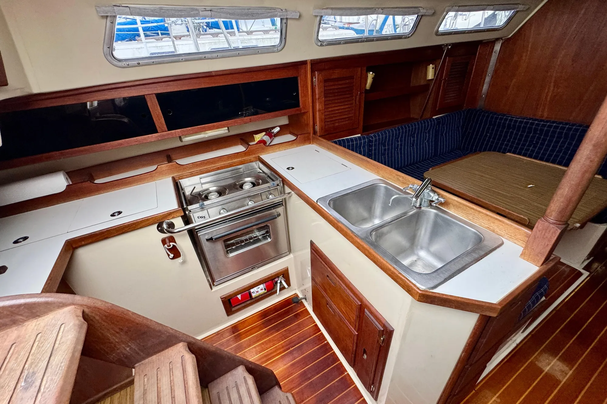 Interior of 1986 Catalina 36 sailboat featuring kitchen, stove, sink, and seating area.