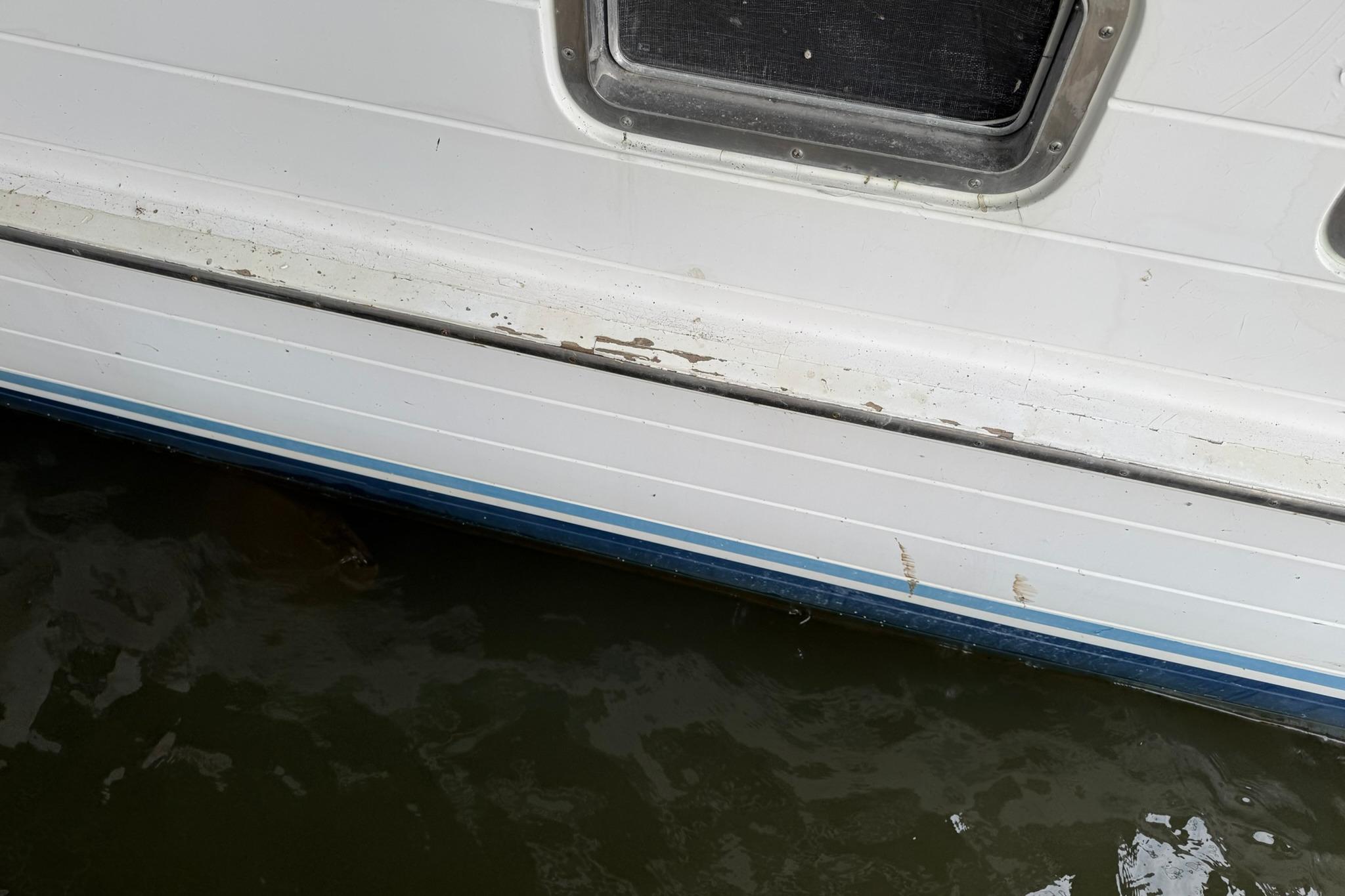 1991 DeFever 44 boat hull with window, showing wear and waterline.