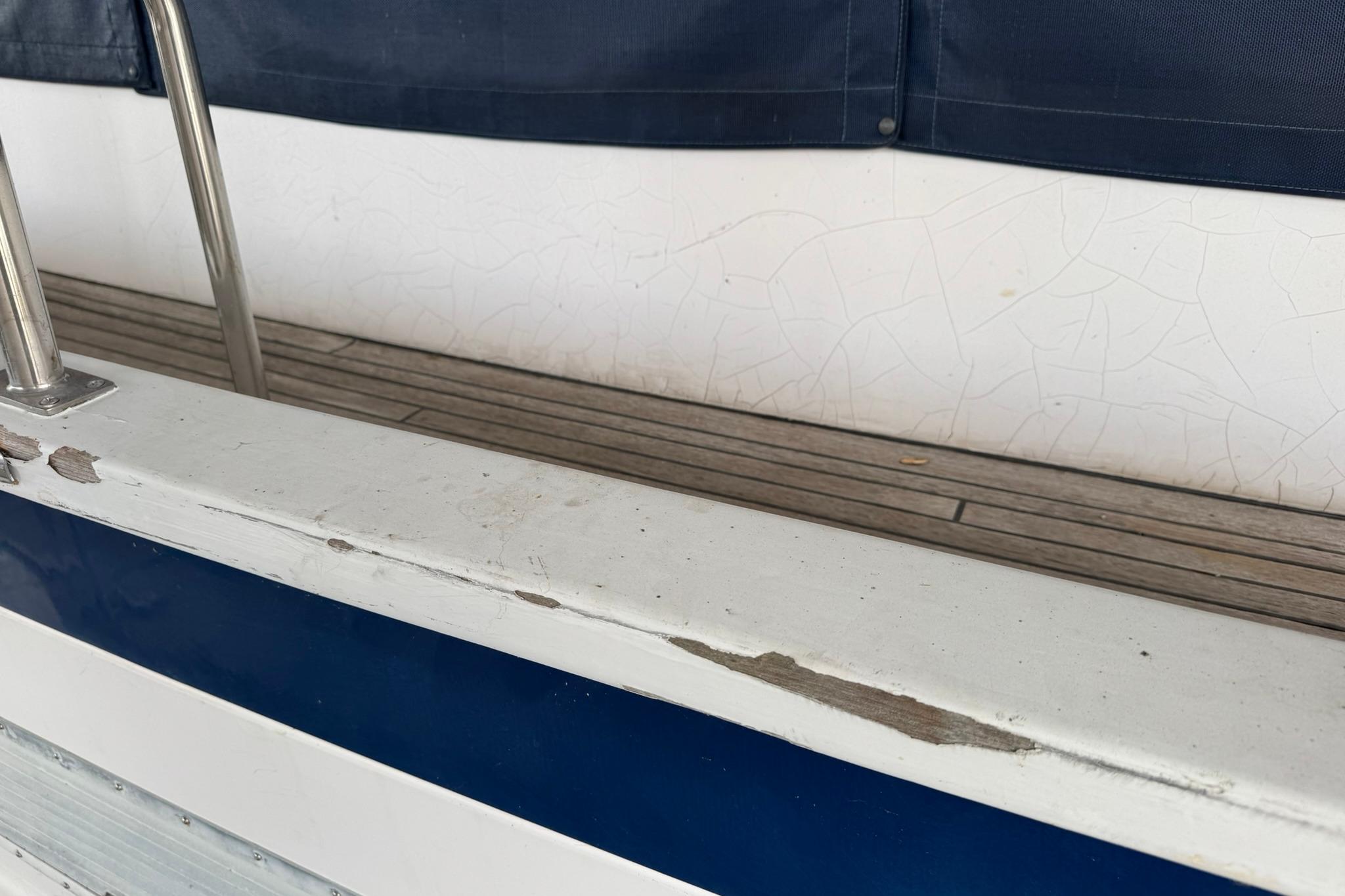 Close-up of 1991 DeFever 44 boat railing with visible paint wear.