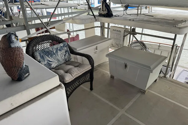Sandial Yacht Photos Pics 1991 DeFever 44 yacht deck with wicker chair, storage boxes, and decorative owl.