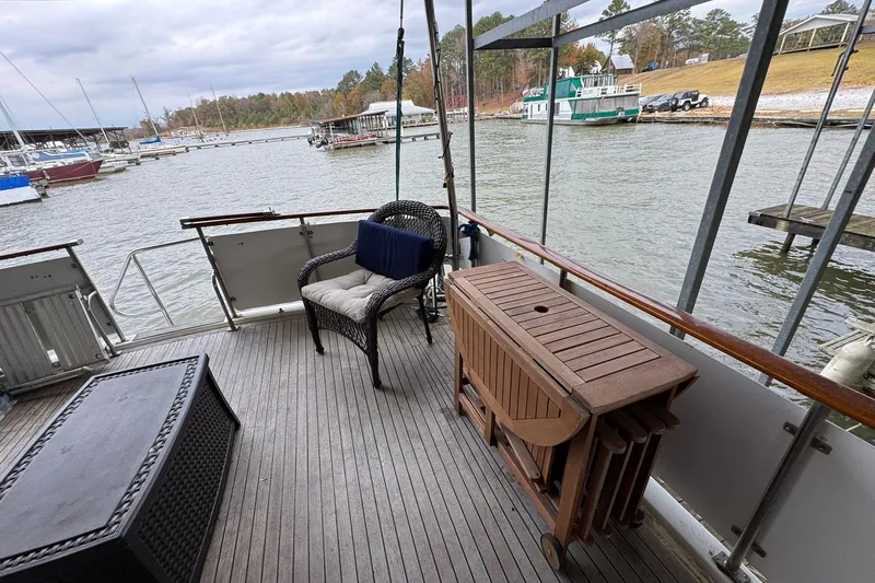 Sandial Yacht Photos Pics 1991 DeFever 44 yacht deck with wicker chair, table, and scenic marina view.