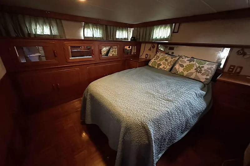 Sandial Yacht Photos Pics Cozy bedroom in 1991 DeFever 44 yacht with wooden cabinetry and floral pillows.