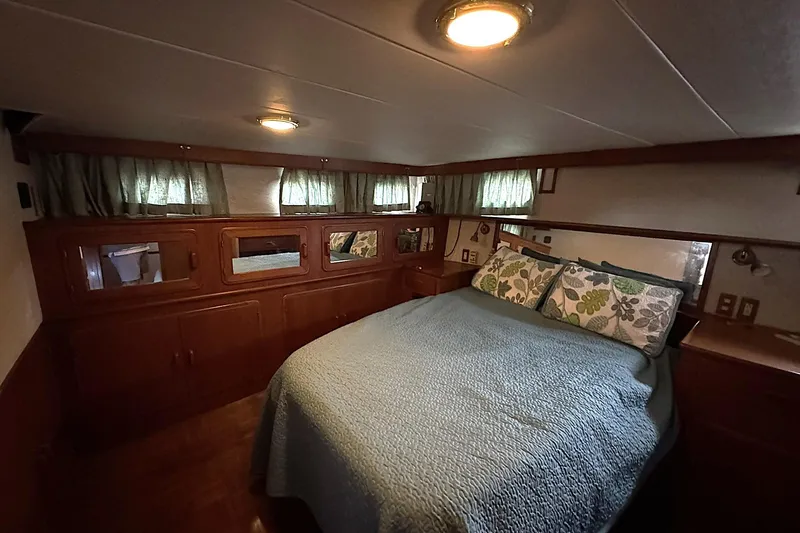 Sandial Yacht Photos Pics Cozy bedroom interior of 1991 DeFever 44 yacht with wood paneling and floral pillows.