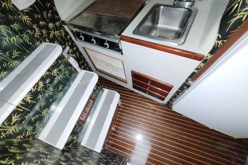  Yacht Photos Pics 1984 Sunny Briggs 37 Express yacht interior with compact kitchen and patterned walls.