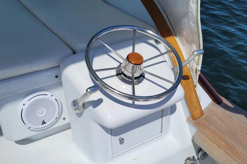  Yacht Photos Pics Steering wheel of 1984 Sunny Briggs 37 Express boat, with speaker and cushioned seating.