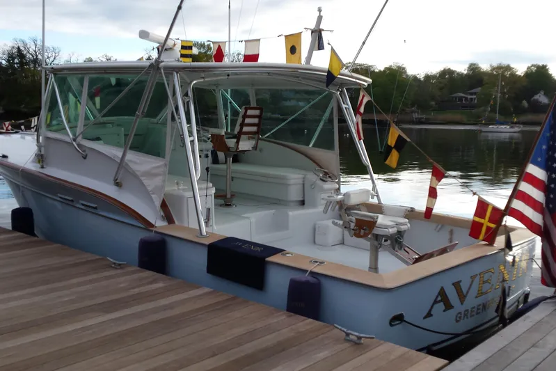  Yacht Photos Pics 1984 Sunny Briggs 37 Express boat docked, adorned with nautical flags and American flag.