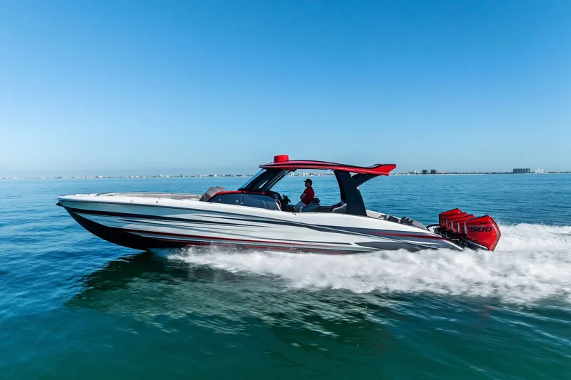  Yacht Photos Pics 2024 MTI V42 speedboat cruising on open water under clear blue skies.