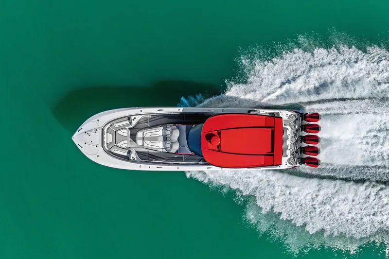  Yacht Photos Pics Aerial view of 2024 MTI V42 speedboat with red accents on turquoise water.